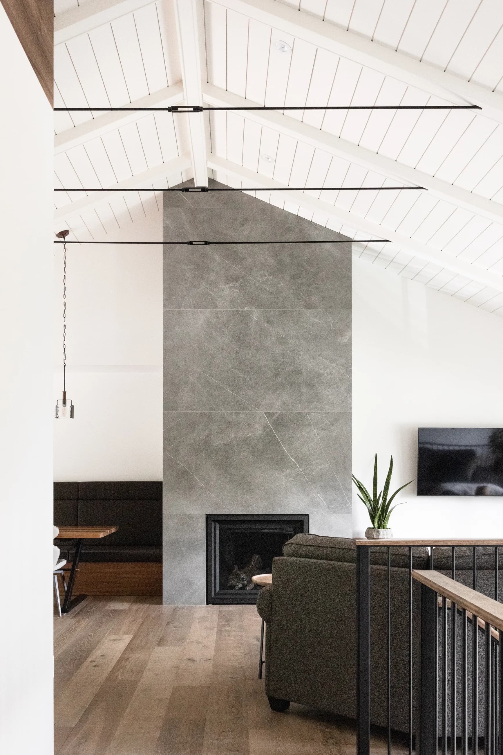 Bedford living room with a monolithic concrete fireplace beneath a white timber ceiling